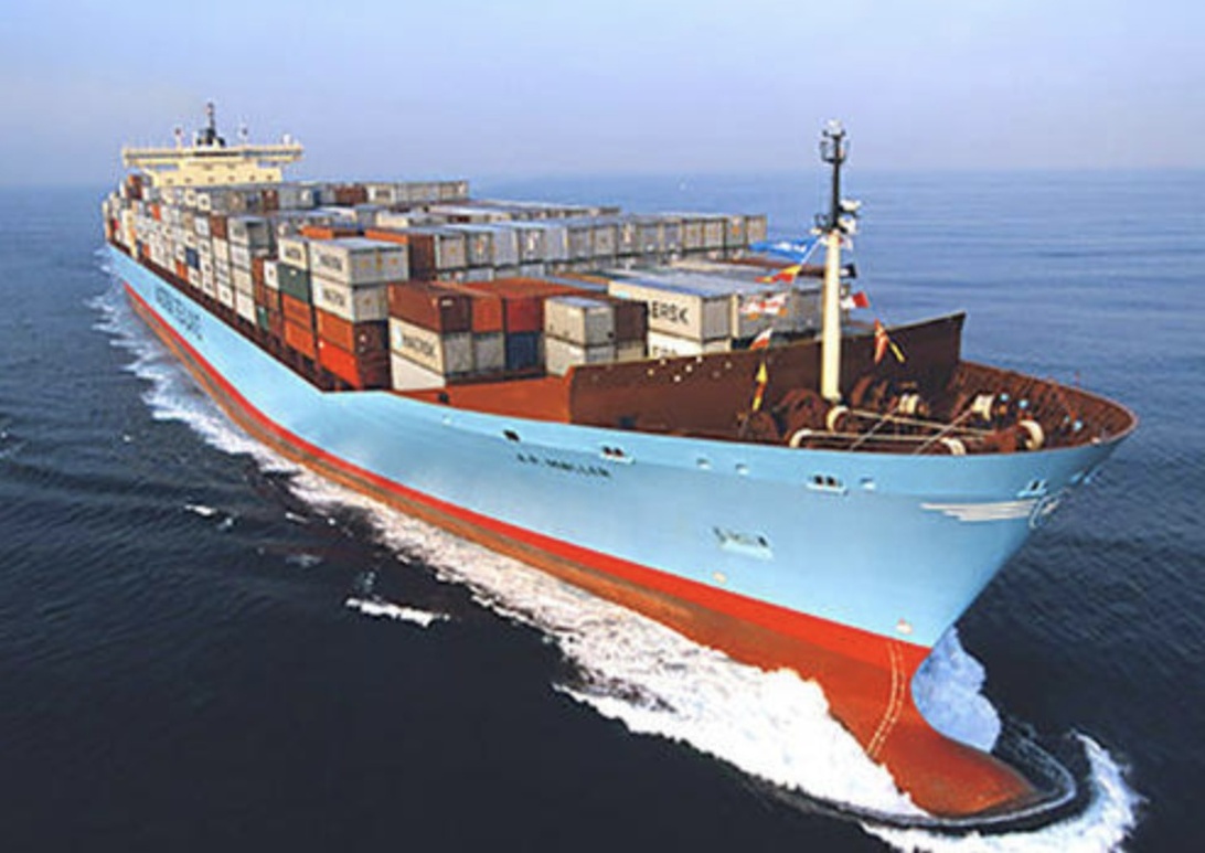 Et stort blått lasteskip med containere som seiler på åpent hav, symboliserer internasjonal bilimport.